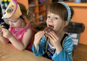 Dzieci jedzące pączki